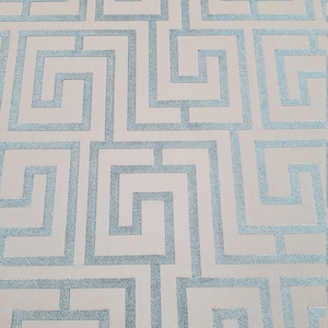 May include: A beige fabric with a repeating pattern of blue interlocking squares. The pattern resembles a maze or a Greek key design.