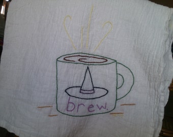 Hand embroidered tea towel with witch brew design