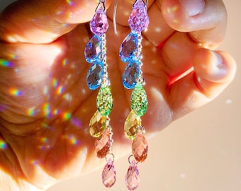 Può includere: Orecchini pendenti a goccia di cristallo arcobaleno con ganci d'argento. Gli orecchini presentano un gradiente di colori, che inizia dal rosa in alto e termina con il verde in basso.
