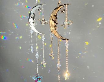 May include: Two crescent moon suncatchers with crystal beads and stars hanging from a gold and silver sun. The suncatchers are made of metal and have a crystal orb hanging from the bottom.