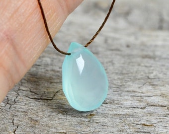 May include: A light blue teardrop-shaped gemstone pendant on a brown leather cord necklace.