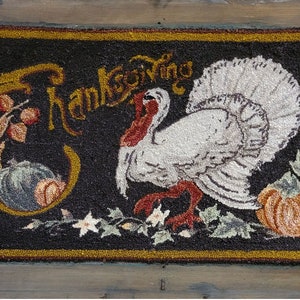 May include: A black and gold doormat with a white turkey and the word "Thanksgiving" in a decorative font. The turkey is standing on a green leaf with a pumpkin beside it.