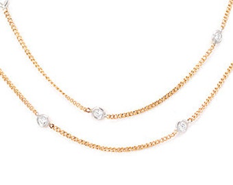 May include: A gold chain necklace with five small diamonds. The necklace is layered, with one chain slightly longer than the other.