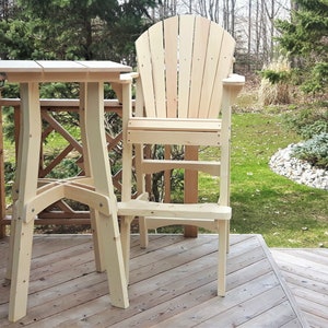 May include: A wooden outdoor table and chair set. The table is square and has a simple design. The chair has a high back and a footrest. The set is made of unfinished wood and is ready to be stained or painted.