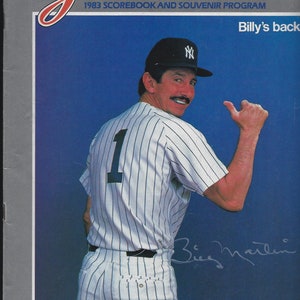 May include: A 1983 New York Yankees Scorebook and Souvenir Program featuring a photo of Billy Martin, the team's manager, wearing a pinstriped uniform and a New York Yankees cap. The cover includes the text "Billy's back" and "Official Publication of the New York Yankees".