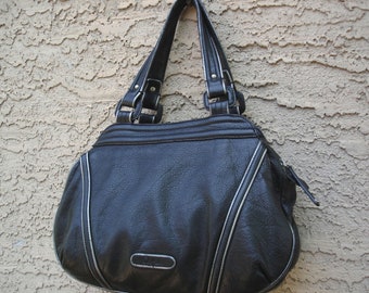 May include: Black handbag with silver trim and handles. The bag has a textured appearance and a curved shape. The handles are attached with silver hardware. The bag has a small, rectangular emblem on the front.