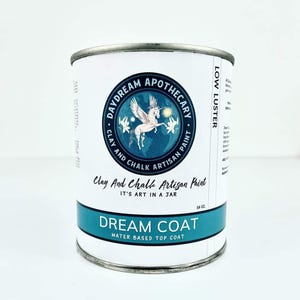 May include: A metal paint can with a white label featuring a blue emblem with a winged unicorn. The label reads "Daydream Apothecary Clay and Chalk Artisan Paint" and "Dream Coat Water Based Top Coat". The can contains 16 oz.