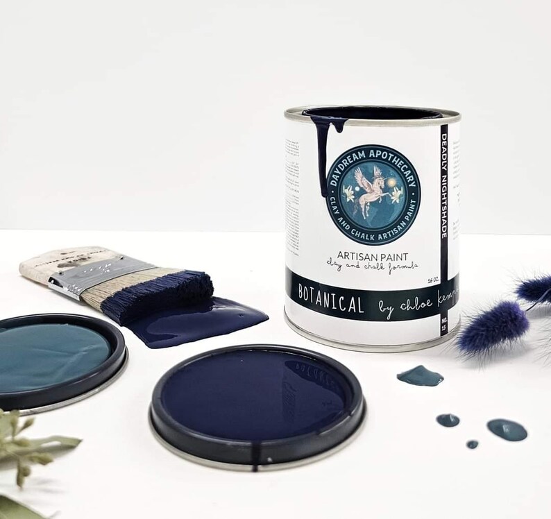 May include: A can of "Daydream Apothecary" "Botanical" artisan paint in "Deadly Nightshade" with a paintbrush and paint can lid. The paint is a deep navy blue. The can has a label with a winged horse illustration.
