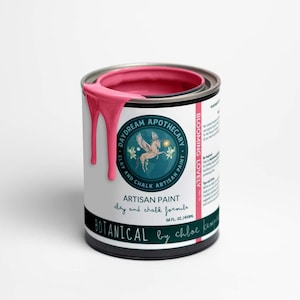 May include: A pink paint can with a white label. The label features a green circle with a winged unicorn and the text "DAYDREAM APOTHECARY. CLAY AND CHALK ARTISAN PAINT."  The label also includes the text "BLOOMING LOVELY" and "ARTISAN PAINT day and chalk formula 16 FL. OZ./473ML BOTANICAL by chloe kempe".