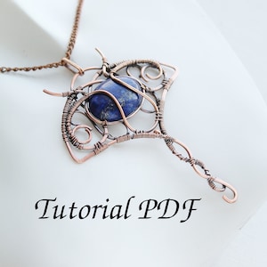 May include: A copper wire wrapped pendant necklace featuring a blue lapis lazuli stone. The pendant is shaped like a stingray and has a delicate wire design. The necklace is on a white surface with the text "Tutorial PDF".