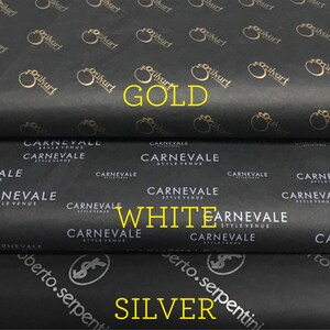 Puede incluir: Papel de seda negro con logotipos y texto dorados, blancos y plateados. La capa superior tiene un logotipo dorado repetido y la palabra "GOLD". La capa intermedia tiene texto blanco que dice "CARNEVALE STYLE VENUE" y la palabra "WHITE". La capa inferior tiene texto plateado y la palabra "SILVER".