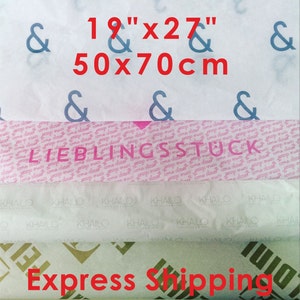 May include: Assorted tissue paper rolls with various patterns and text. The top layer features blue ampersands, and the dimensions are 19" x 27" (50 x 70cm). The middle layer has the word "LIEBLINGSSTUCK".