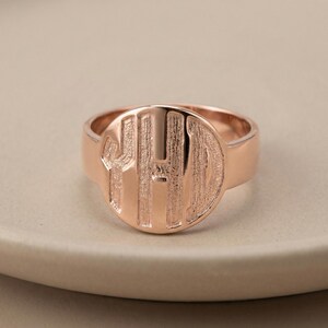 Op de afbeelding: Rosegouden zegelring met een cirkelvormige voorkant. De voorkant heeft de gegraveerde initialen "YHD" in een vetgedrukte, schreefloze lettertype. De ring heeft een gepolijste afwerking en een brede band.