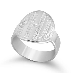 Op de afbeelding: Een zilveren zegelring met de initialen "YHD" in een vet, schreefloos lettertype binnen een ovale vorm. De ring heeft een gepolijst, reflecterend oppervlak en een eenvoudige band.