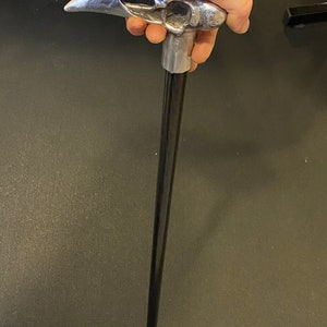May include: A black walking stick with a silver skull-shaped handle.