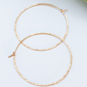 May include: A pair of gold hammered hoop earrings. The earrings are simple and elegant, and they would make a great gift for any occasion.