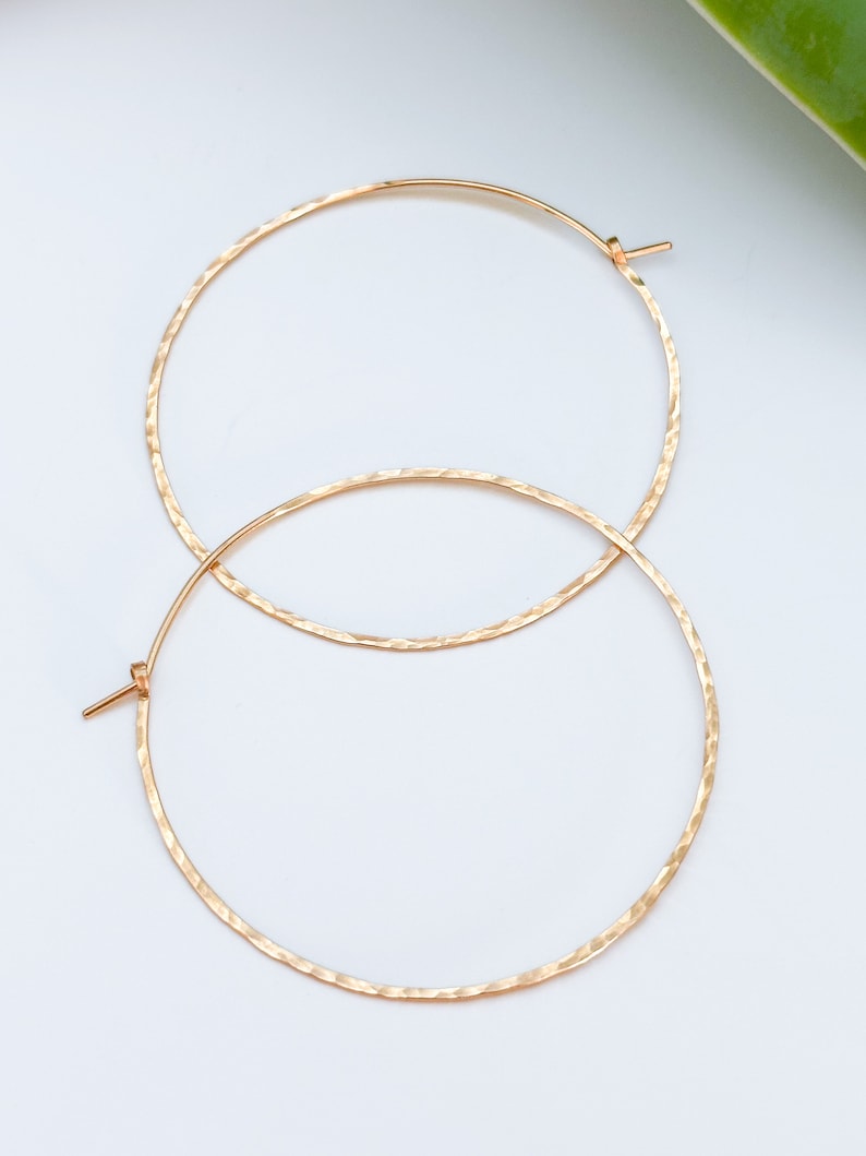 May include: A pair of gold hammered hoop earrings. The earrings are simple and elegant, and they would make a great gift for any occasion.