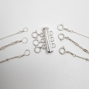 Può includere: Estensione per collana multifilo in argento con cinque maglie a catena e una chiusura a scorrimento. L'estensione è progettata per regolare la lunghezza di una collana.