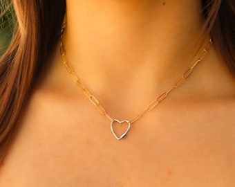 May include: A gold chain necklace with a silver heart pendant.