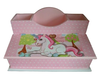 May include: Pink wooden desk organiser with a unicorn design. The organiser has three compartments and a drawer. The unicorn is white with a pink mane and tail.