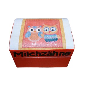 May include: Red wooden box with a colorful owl design and the text "Milchzähne" on the front.