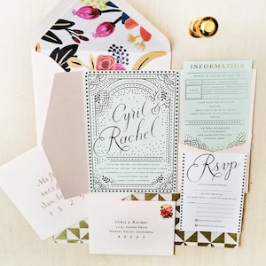 May include: A wedding invitation suite with a teal and black geometric design. The invitation features the names Cyril and Rachel in a cursive font. The RSVP card has a gold and white geometric pattern.