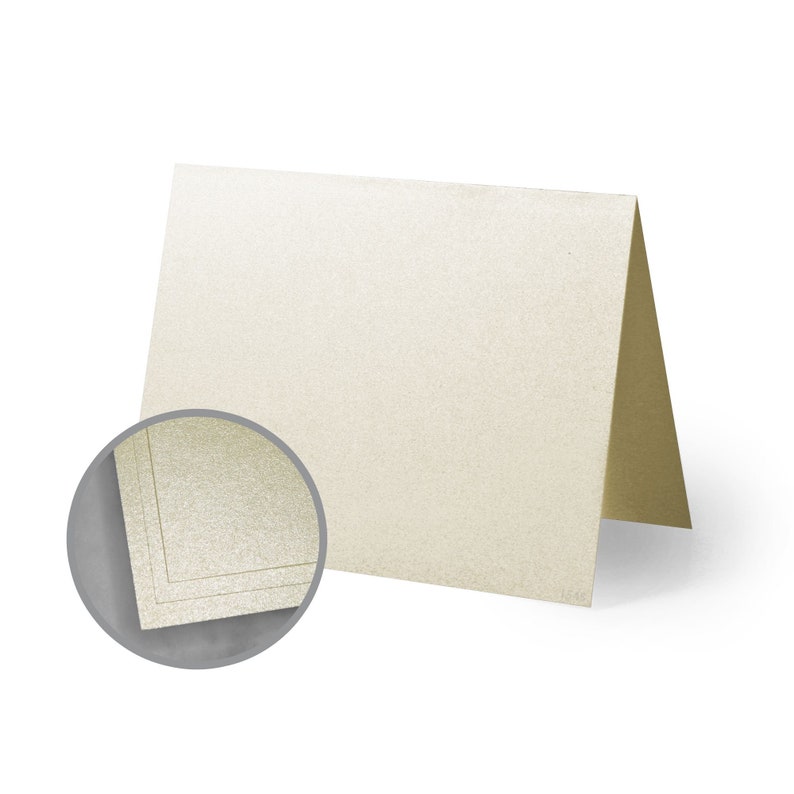 May include: A blank ivory card with a subtle shimmer finish. The card has a gold border and is folded in half.