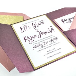 May include: A wedding invitation with a burgundy and gold glitter border. The invitation reads "Ella Grant & Ryan Howard" and includes the wedding date, time, and location. The RSVP card is visible in the background.