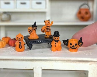 Könnte beinhalten: Ein Set mit sechs Miniatur-Halloween-Figuren, darunter ein Kürbis, ein Schneemann, eine Katze und drei Jack-o'-Lantern. Die Figuren sind aus orangefarbenem und schwarzem Kunststoff und etwa 5 cm hoch.