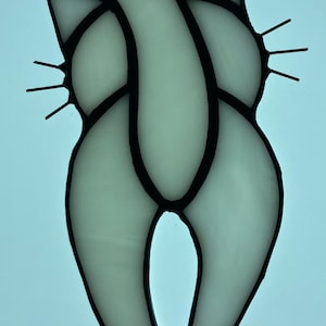 May include: A stained glass cat figurine with a white background. The cat is outlined in black and has a long tail curled over its back.