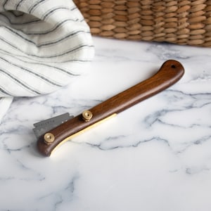 May include: A wooden handled razor with a gold trim and a replaceable blade. The blade is labeled "PLATINUM".
