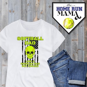 May include: White t-shirt with a green and black softball skull graphic and the text "Softball Dad Like a Regular Dad But Cooler" on a white and black American flag background.