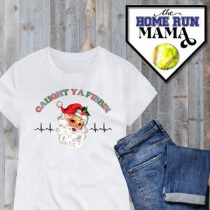 Puede incluir: Camiseta blanca con un gráfico de Santa Claus rojo y blanco y el texto "Caught Ya Fibbin" en una fuente verde, roja y blanca. El gráfico incluye un monitor de frecuencia cardíaca.