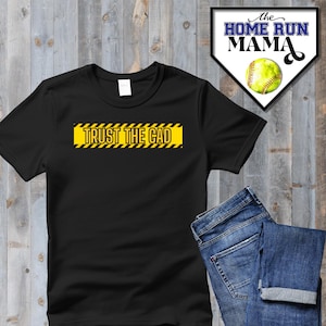 Puede incluir: Camiseta negra con un diseño de cinta de advertencia amarilla y negra que dice "TRUST THE CAD".