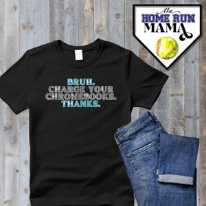 May include: Black t-shirt with the text "BRUH. CHARGE YOUR CHROMEBOOKS. THANKS." in blue and white lettering.