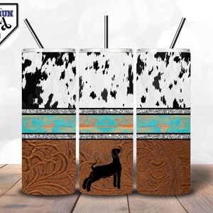 Può includere: Tre bicchieri in acciaio inossidabile con stampa in pelle di mucca, accenti turchese e argento e un motivo in pelle marrone. Il bicchiere centrale presenta una silhouette nera di una capra.