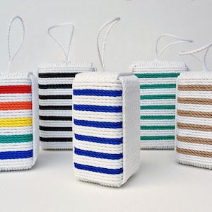 May include: Five small, white, rectangular boxes with rope handles. Each box has a different colored stripe pattern: red, orange, yellow, green, and blue; black and white; blue and white; green and white; and brown and white.