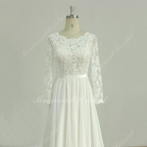 May include: A white lace wedding dress with long sleeves and a chiffon skirt. The dress has a fitted bodice and a flowing skirt.