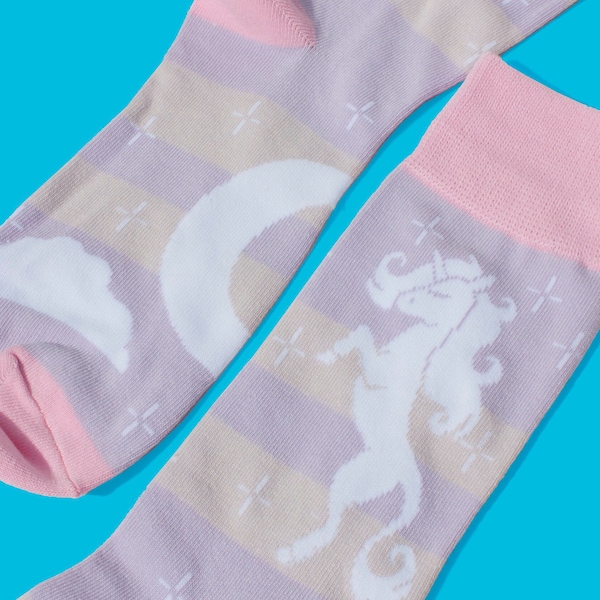 May include: A pair of pink and purple socks with a white unicorn and crescent moon design. The socks have a striped pattern and a pink cuff.