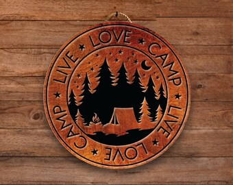 May include: A round wooden sign with the text "Live Camp Love" repeated twice in a circle. The sign features a silhouette of a forest with a tent and a campfire.