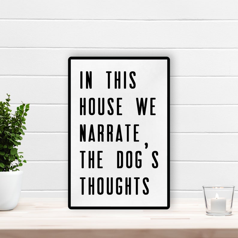 May include: Black and white sign with the text "In this house we narrate, the dog's thoughts".