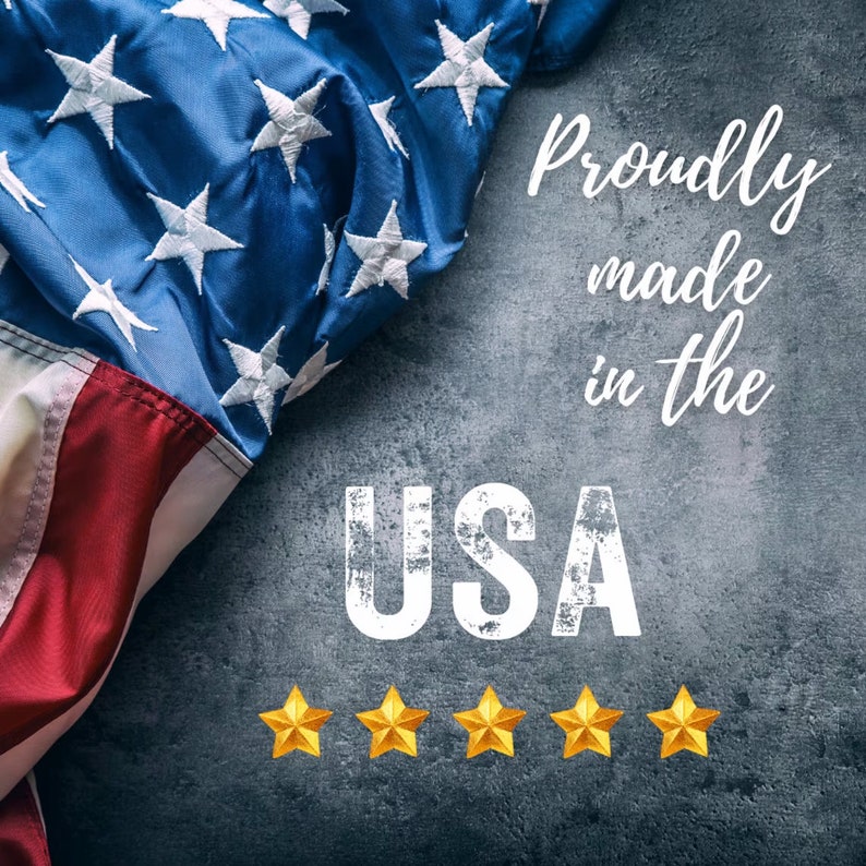 May include: An American flag draped over a gray textured surface with the text "Proudly made in the USA" and five gold stars below.
