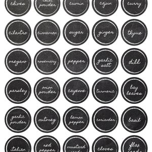 Peut inclure: &Eacute;tiquettes d'&eacute;pices et d'herbes en ardoise noire et blanche avec des noms &eacute;crits &agrave; la main, notamment ciboulette, poudre de chili, cumin, cajun, curry, coriandre, cannelle, sucre, gingembre, thym, origan, romarin, poivre, sel d'ail, aneth, persil, poudre d'oignon, piment de Cayenne, curcuma, feuilles de laurier, poudre d'ail, muscade, poivre noir, coriandre, basilic, italien, poivre rouge, graines de moutarde, clous de girofle et graines de lin.