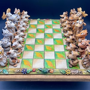 Peut inclure: Un jeu d'échecs fantaisiste avec des pièces sur le thème des animaux. Le plateau présente un motif à carreaux vert et beige avec des feuilles. Les pièces sont des figurines d'animaux détaillées de différentes couleurs, sur une base en bois avec une bordure florale et feuillue.