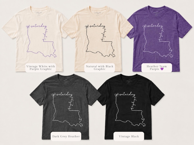 May include: Five short-sleeve crew neck t-shirts in vintage white, natural, heather team purple, dark grey heather, and vintage black. Each shirt features a line art graphic of the state of Louisiana with the word saturday and a bow.