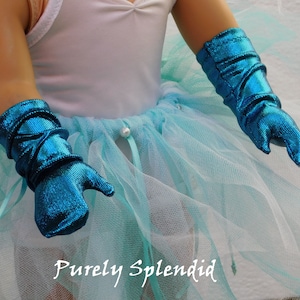 Puede incluir: Un par de guantes met&aacute;licos azul turquesa con una falda de tul blanca y un leotardo blanco. El texto "Purely Splendid" es visible en la esquina inferior derecha de la imagen.
