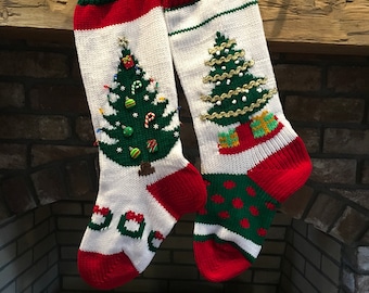 Puede incluir: Dos calcetines de Navidad rojos y verdes con detalles blancos colgados de una repisa de madera. Cada calcetín tiene un árbol de Navidad verde con adornos y un tronco marrón. Un calcetín tiene una guirnalda dorada en el árbol y el otro tiene bastones de caramelo rojos y verdes.