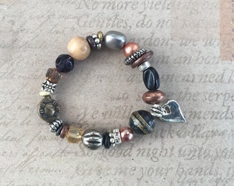 A simple black and copper bracelet with heart pendant.