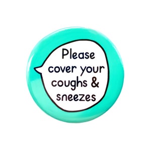 May include: A turquoise blue round button with a white speech bubble that says "Please cover your coughs & sneezes".