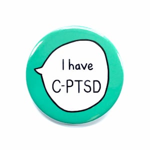 May include: A teal blue button with a white speech bubble that says "I have C-PTSD".